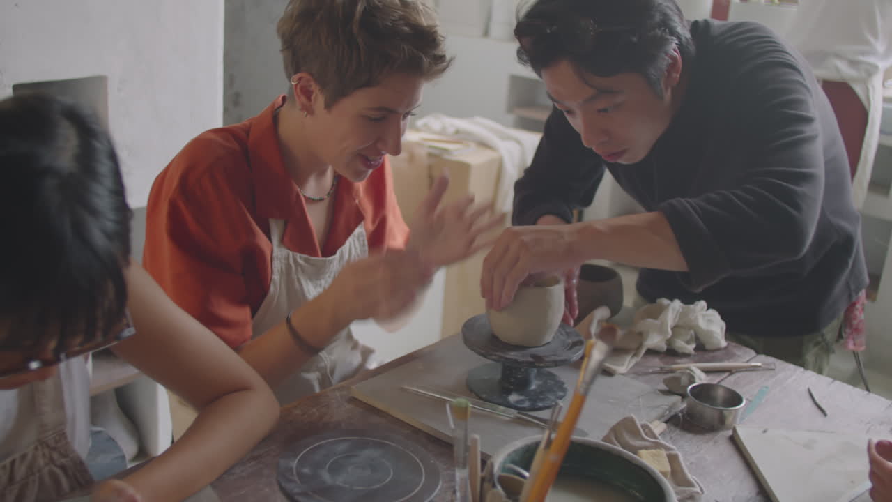 Young Women Learning to Potter with Teacher at Ceramics Class