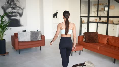 woman walking through a stylish modern apartment with open kitchen.