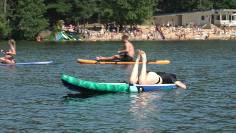 girl laying on sup board.  beach background. hot sunny summer day.