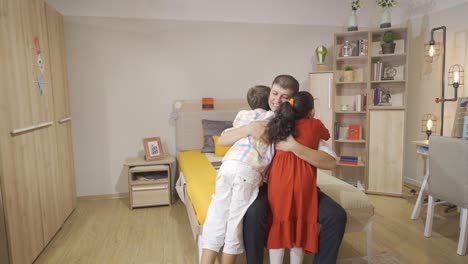the two children run and hug their father.