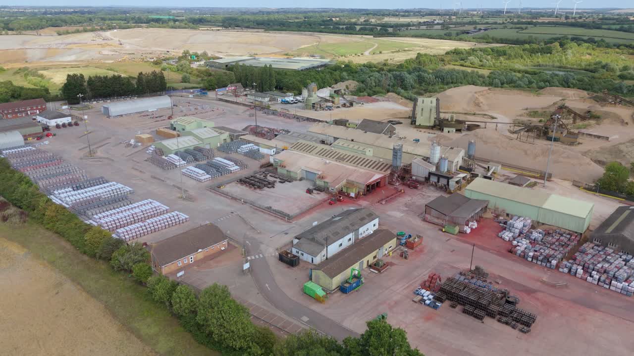 Top down aerial footage of industrial buildings and storage yards for aggregates and construction Rugby England UK