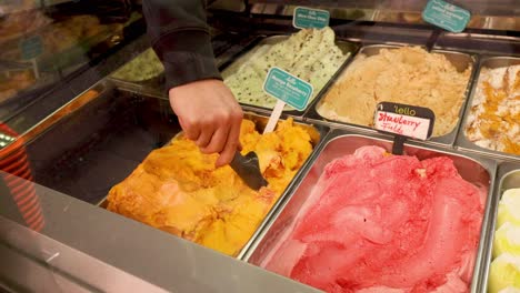 hand scooping ice cream from a display