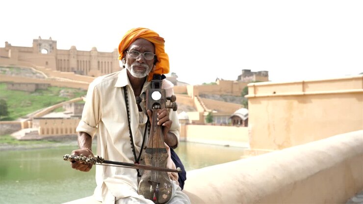 Un vieil homme traditionnel jouant du Sarangi devant la forteresse historique