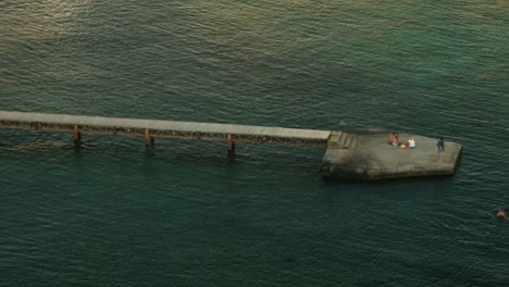 People Relaxing on a Pier Over Water