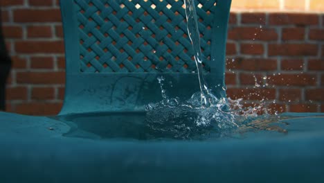 super slowmotion shot of water whirling on garden chair bottle at 1000fps