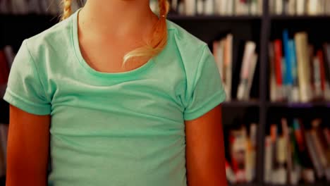 Portrait-of-happy-schoolgirl-standing-in-library-4k