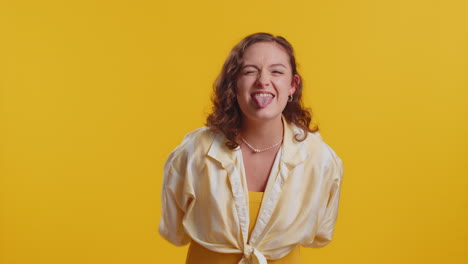cheerful funny bully young woman showing tongue making silly faces fooling around joking teasing