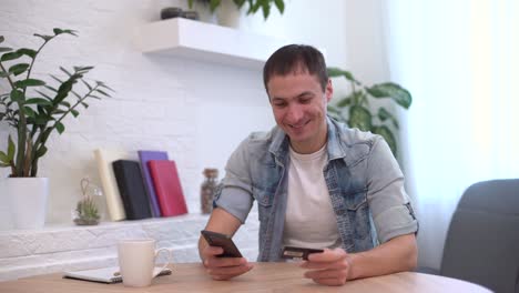 hombre de negocios banca en línea usando teléfono inteligente compras en línea con tarjeta de crédito sentado