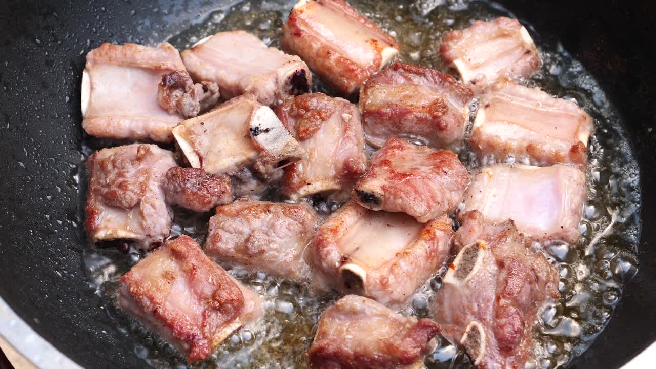 Costine di maiale fritte in olio caldo