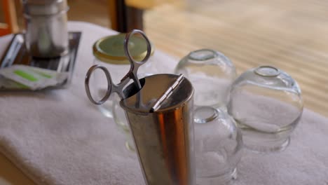 table-with-Chinese-medicine-implements-such-as-needles,-scissors-and-suction-cups-for-cupping-therapy