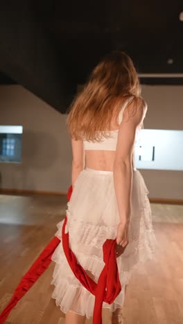 woman performing contemporary dance with red ribbons