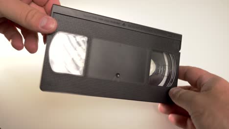 Eine-Alte-Und-Abgenutzte-VHS-Kassette-In-Den-Händen-Eines-Mannes