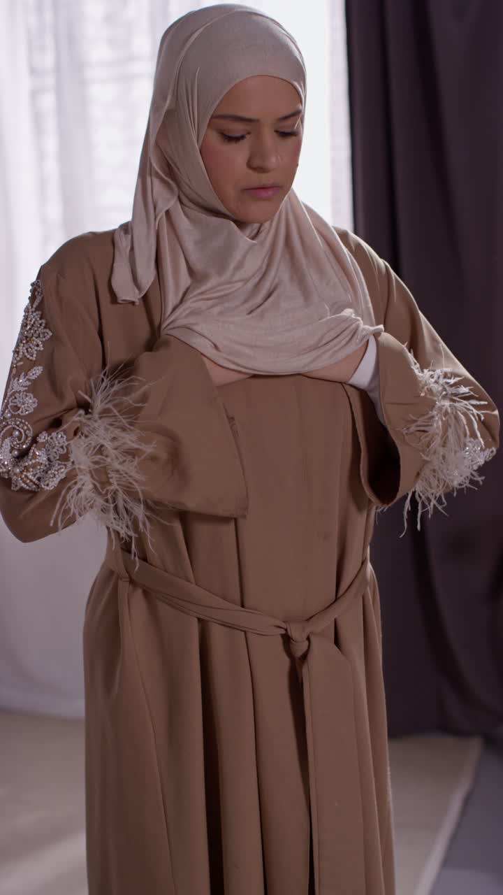Vertikal video af muslimsk kvinde iført hijab derhjemme, beder stående på bedetæppe 2