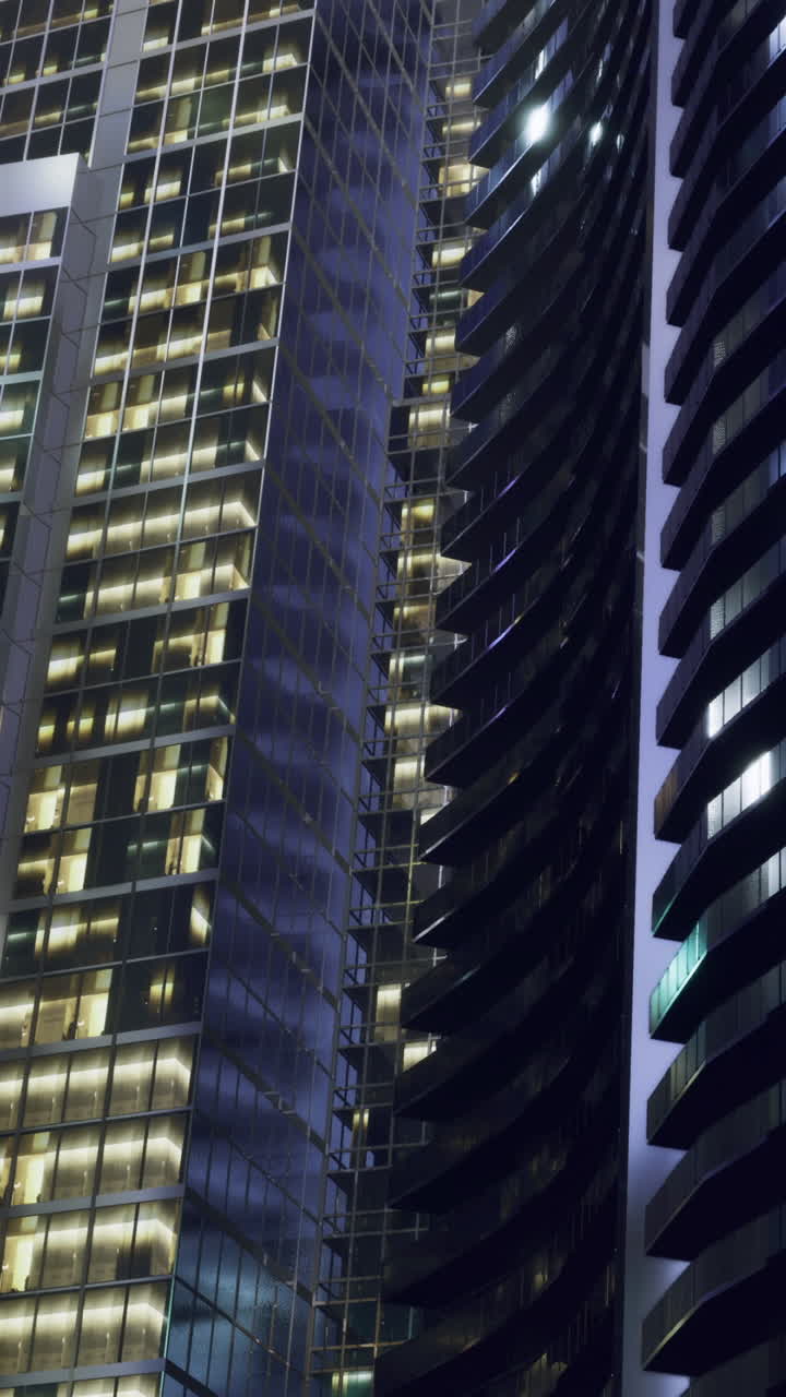 Edifícios da cidade à noite com luzes brilhando em janelas e superfícies de vidro