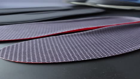 close-up of black and red orthopedic insoles with hexagon pattern