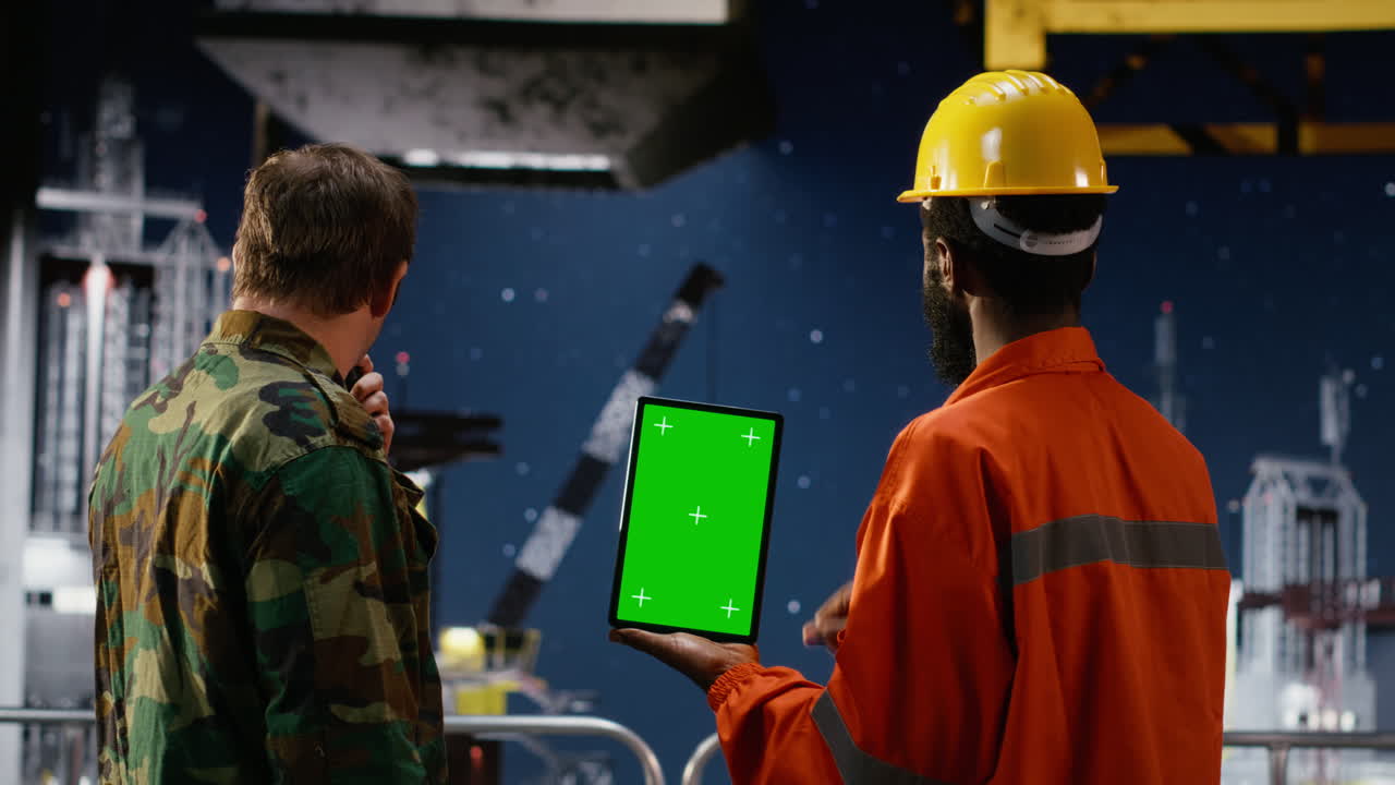 Vertical green screen with soldier and engineer overseeing oil production