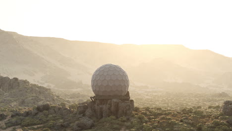 a large radar dome sits on a mountain top in a desert landscape