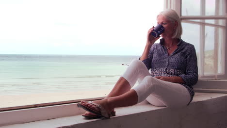 woman sits at window and looking at beach view shot on r3d