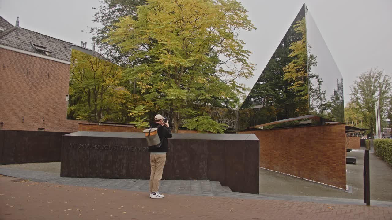 Man taking photo with his phone of the National Holocaust Names Memorial in Amsterdam, the Netherlands