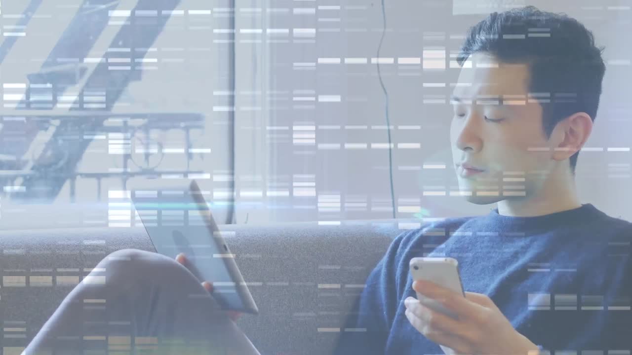 ソファに座ってスマートフォンとタブレット端末を使用しているアジア人男性の背景に、モザイクの四角形。