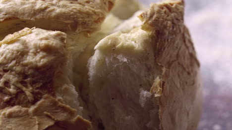 Hands-Tearing-Off-Chunk-of-Fresh-Baked-Steamy-Bread,-Close-Up