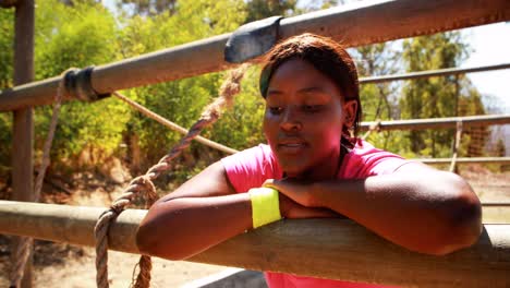 tired woman relaxing on outdoor equipment during obstacle course