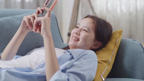 teenager relaxing on couch and using smartphone