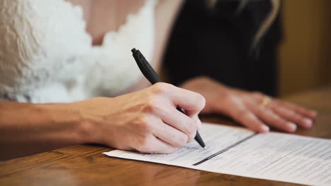 bride and groom signing a document during a wedding