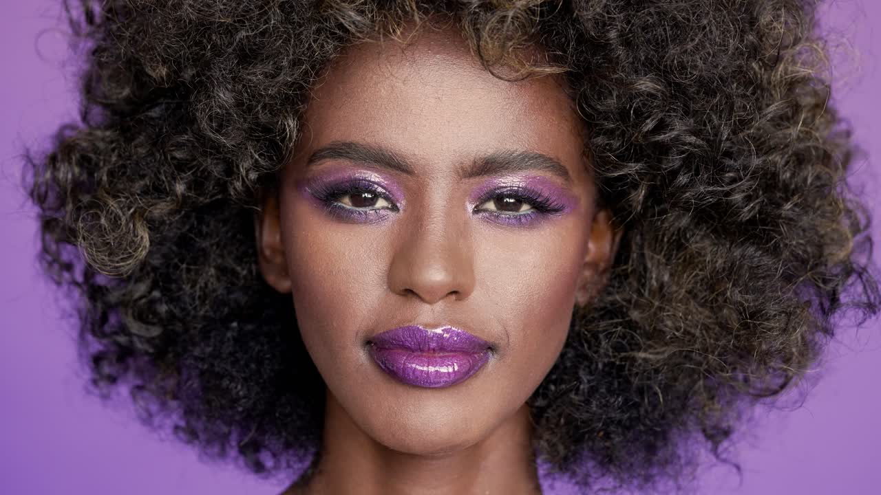 mujer elegante con maquillaje púrpura y afro
