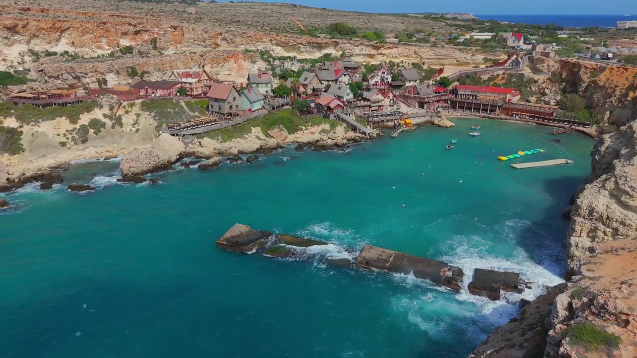 Popeye Village dall'alto, una scena accattivante di capanne colorate, acque limpide e scogliere spettacolari a Malta.