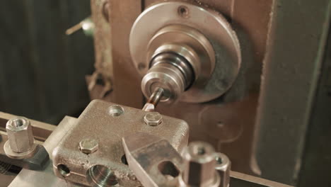 close-up of machinist's hands operating the lever and buttons on industrial machinery