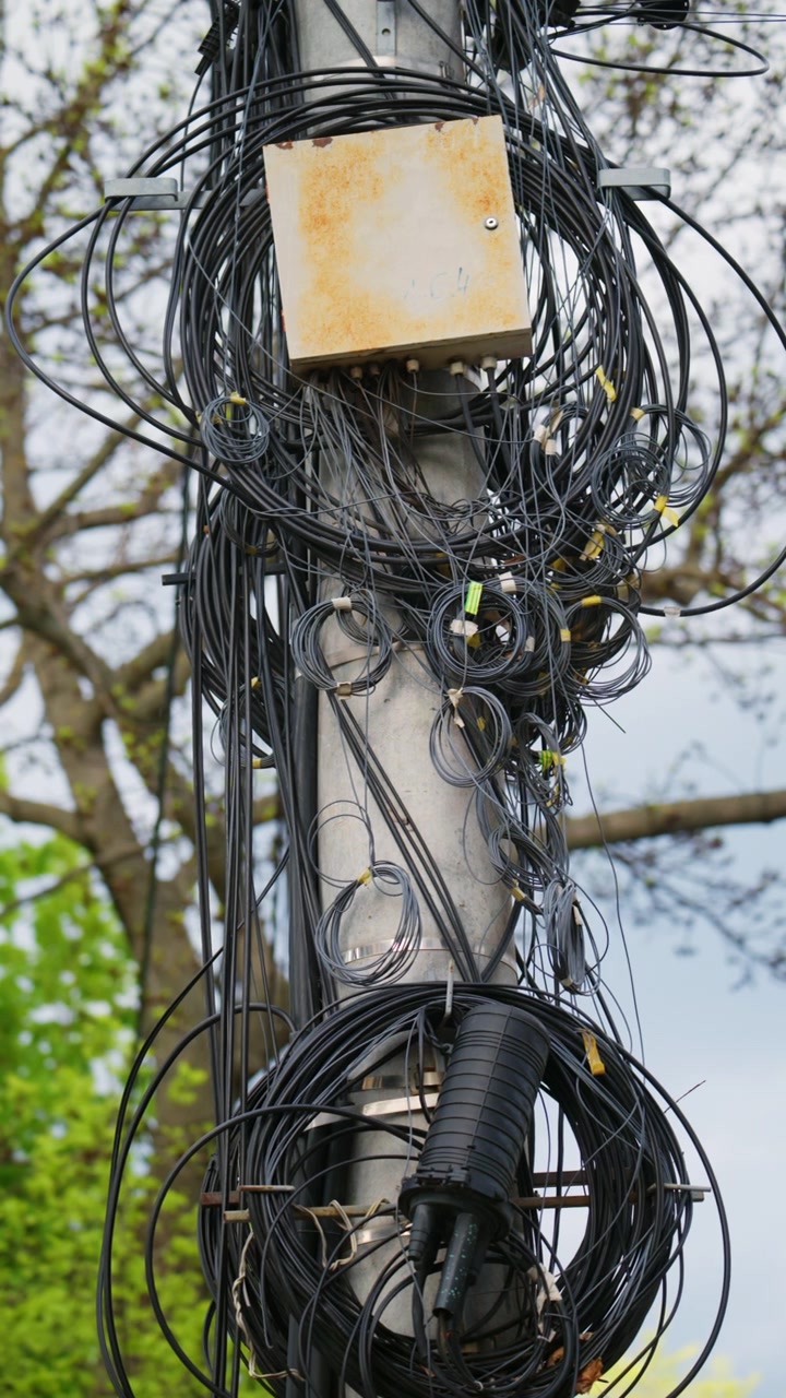 Close up of tangled cables and wires on a utility pole