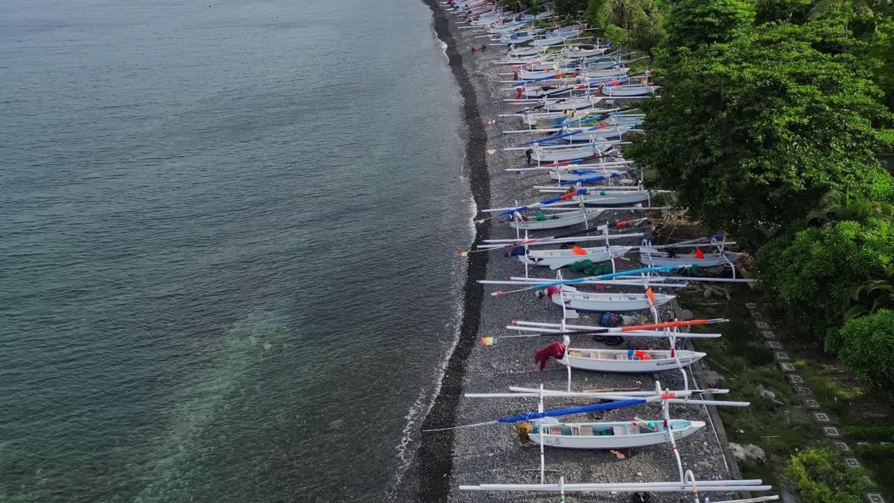 drone flying over a beach revealing how many fishing boats are on the beach