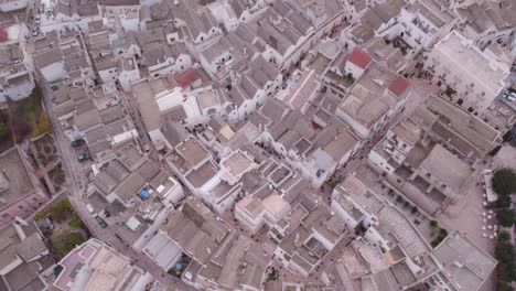 Locorotondo-village-with-white-buildings-and-labyrinth-of-narrow-alleys,-top-down