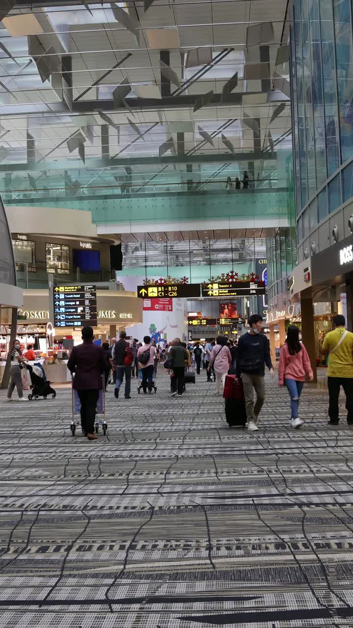 pasajeros caminando a través de una terminal de aeropuerto ocupada