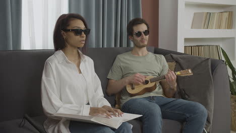 blind friends sitting on a sofa in a flat