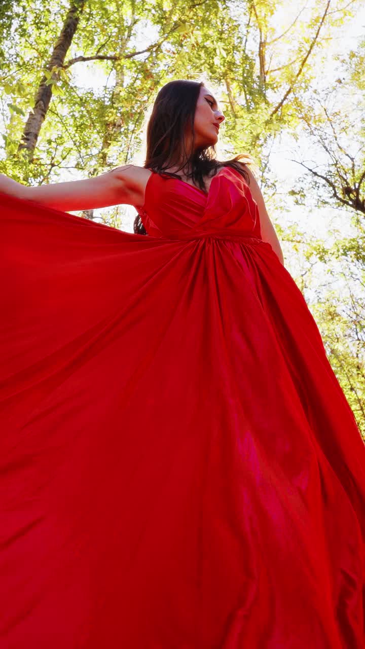 A Captivating Dance in Nature: A Model Twirls Gracefully in a Stunning Flowing Dress Surrounded by the Beauty of Autumn Leaves and Sunlight