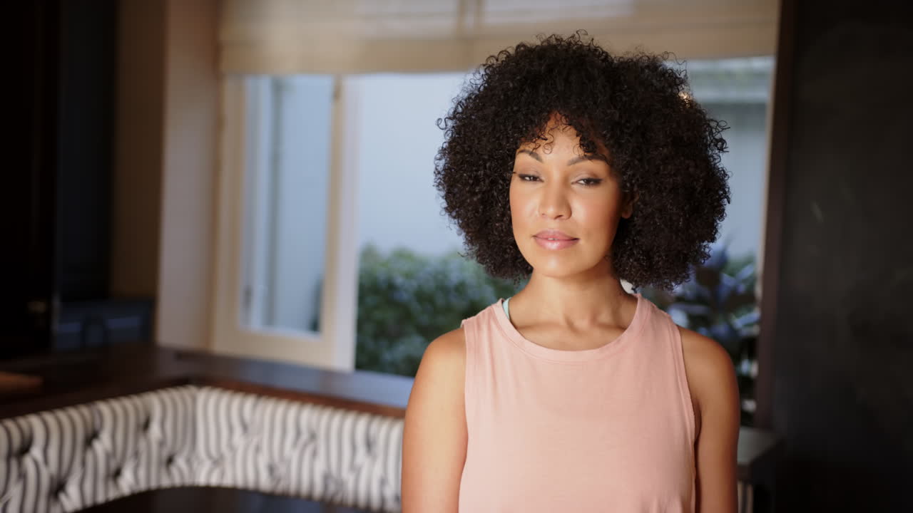Smiling woman in casual clothing standing indoors, looking at camera confidently, copy space