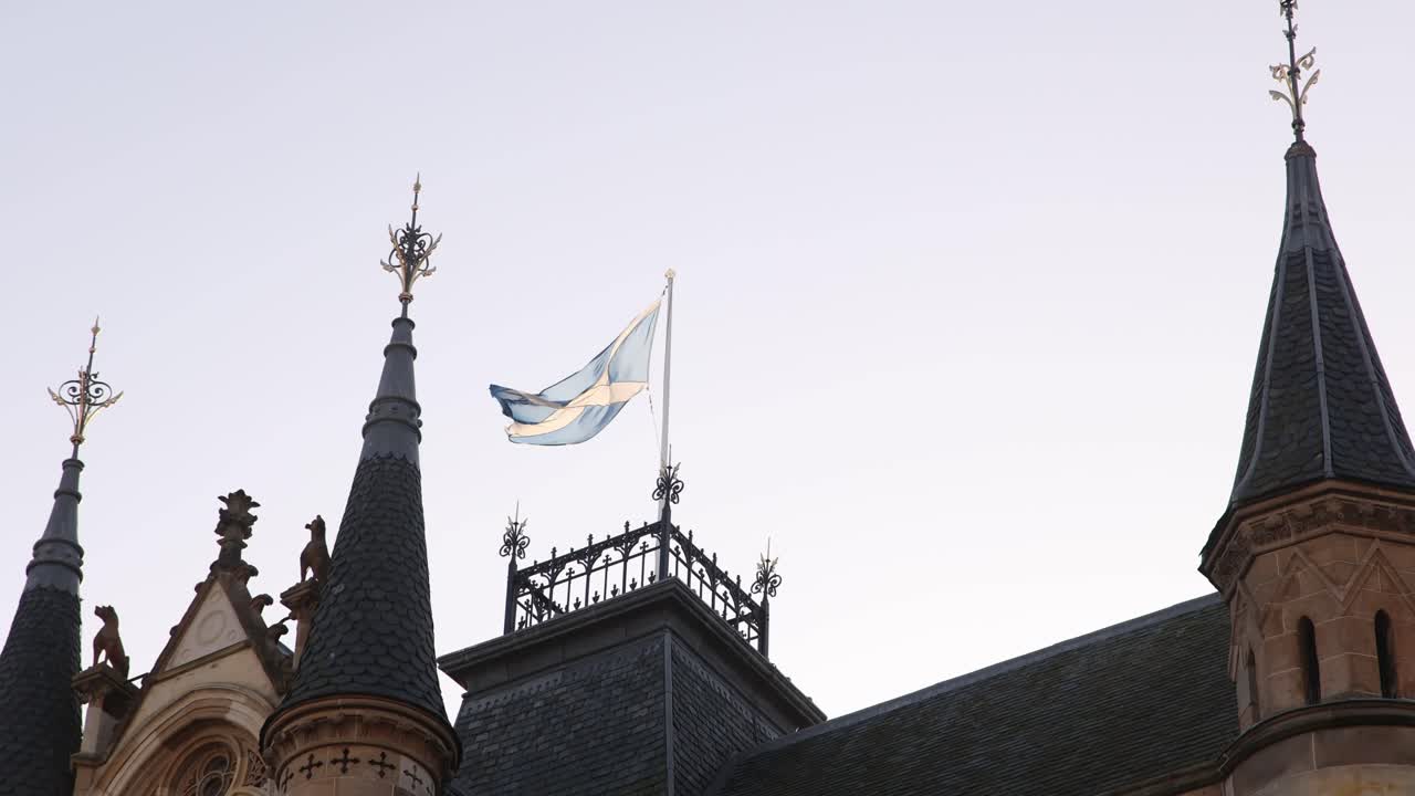 bandera escocesa ondeando sobre el palacio del gobierno del pueblo a lo largo de la calle principal en inverness, escocia en las tierras altas