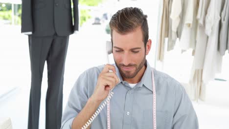 un guapo diseñador de moda trabajando en su escritorio