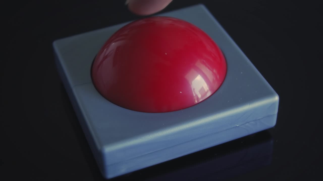 dedo empujando un pequeño timbre rojo