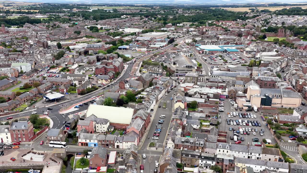 Drone slowly moves over Dundee cityscape, revealing urban architecture, roads, and rooftops in daylight