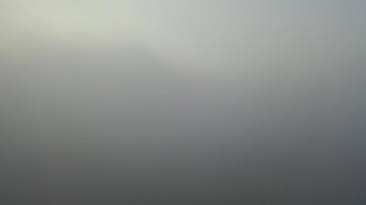 Drone Rises Above Thick Fog to Reveal Golden Sunrise