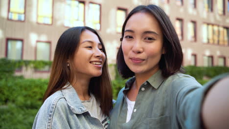 Group-Of-Three-Young-Japanese-Friends-Looking-At-Camera-And-Taking-Selfie-Photos-Outdoors