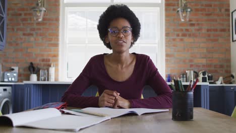 Feliz-Adolescente-Afroamericana-En-La-Mesa-De-La-Cocina-En-Una-Lección-En-Línea-Usando-Una-Computadora-Portátil