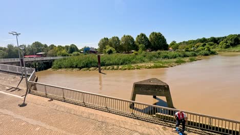 person walking across bridge over river
