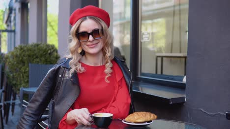 slow morning aesthetic. a parisian woman tastes coffee and a croissant on the terrace. coffee break with croissant. lifestyle of a modern urban young woman