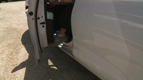 woman walking and getting into/out of cars in a parking lot