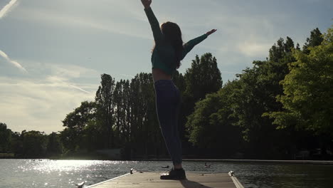 gorgeous italian woman with arms raised looking at sunset view over the lake