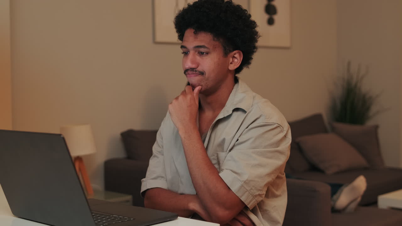 Young Man Waving and Talking During a Video Call on Laptop